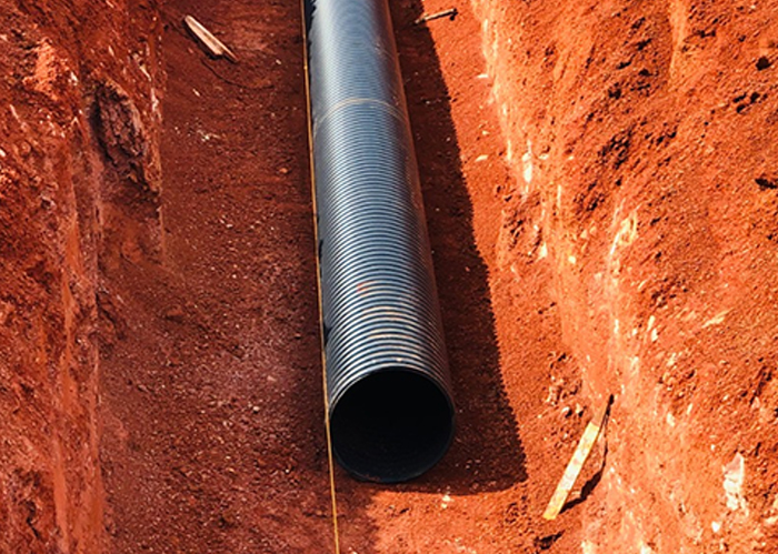 Tubo Tucano Infraestrutura de tecnologia avançada, estendendo-se em uma vala de terra, representando uma solução de qualidade para diversas aplicações de infraestrutura.
